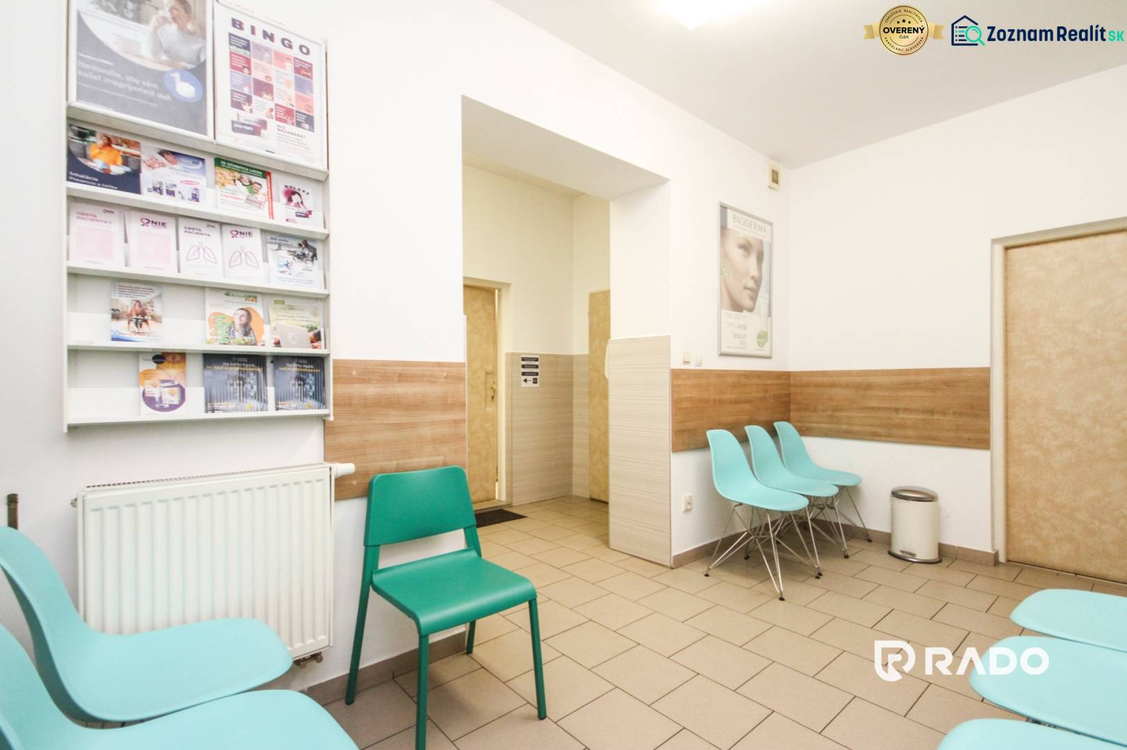 A waiting room with turquoise chairs and magazines, equipped with a wooden decor floor.
