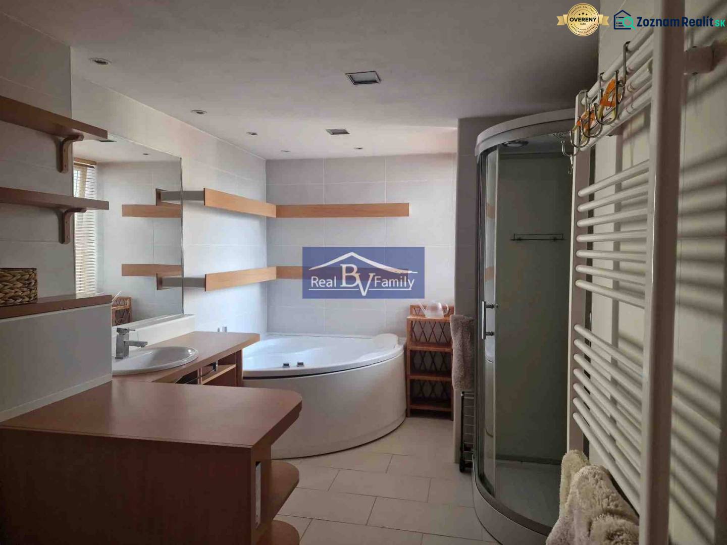 Bathroom in a 2-room apartment, with a bathtub, shower corner, and shelves.