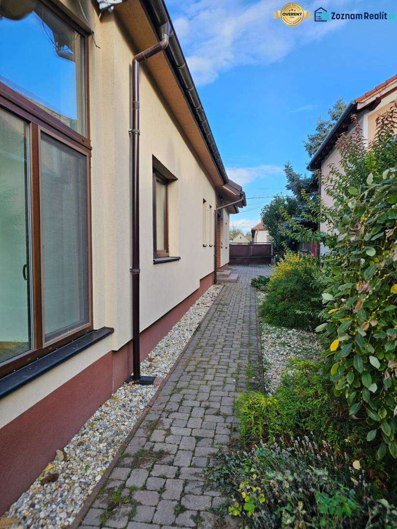 A view of the side of a family house on Štúrova Street in Vráble with a paved walkway.