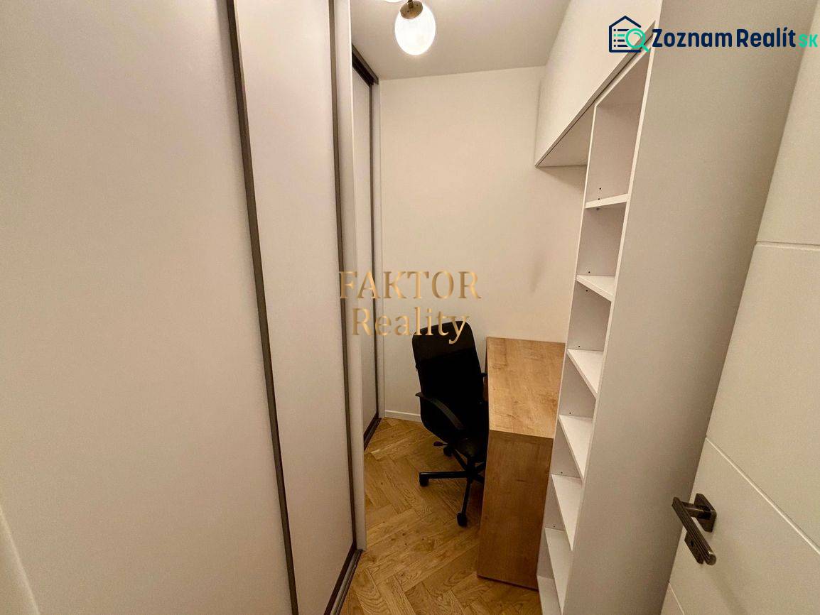 A small study in a 2-room apartment with a wooden decor floor and built-in wardrobes.