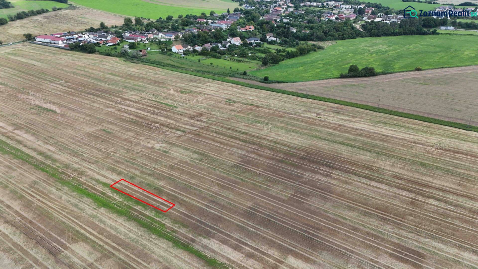 Agricultural and forest lands near Nová Ves nad Váhom with a village in the background.