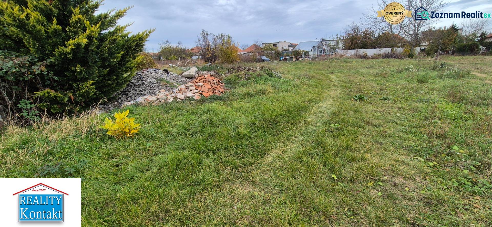Green residential land in Tvrdošovce with piles of debris and dense vegetation.