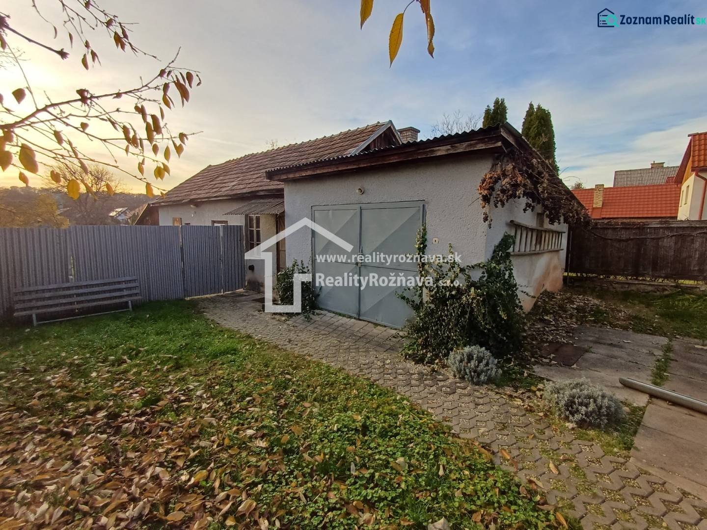 A family house in Dlhá Ves with a courtyard, lawn area, and garage surrounded by a fence.