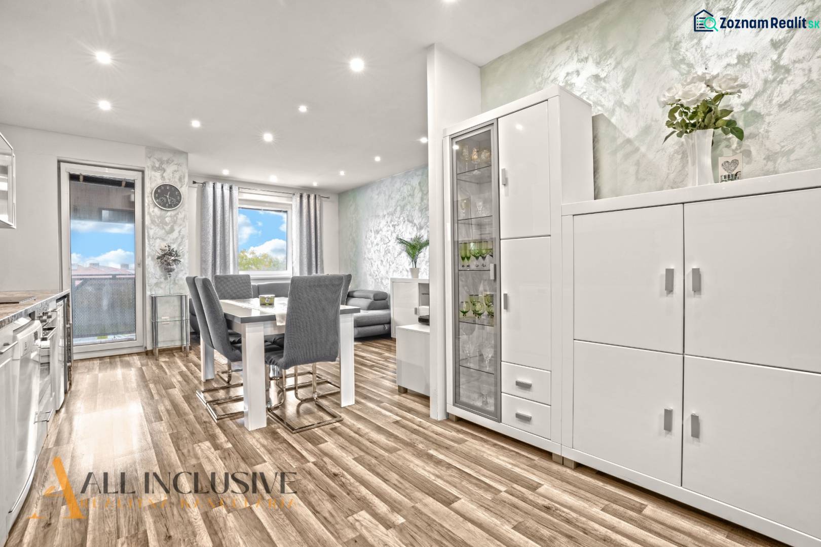 A bright interior of a 3-room apartment with a wooden decor floor and white furniture.