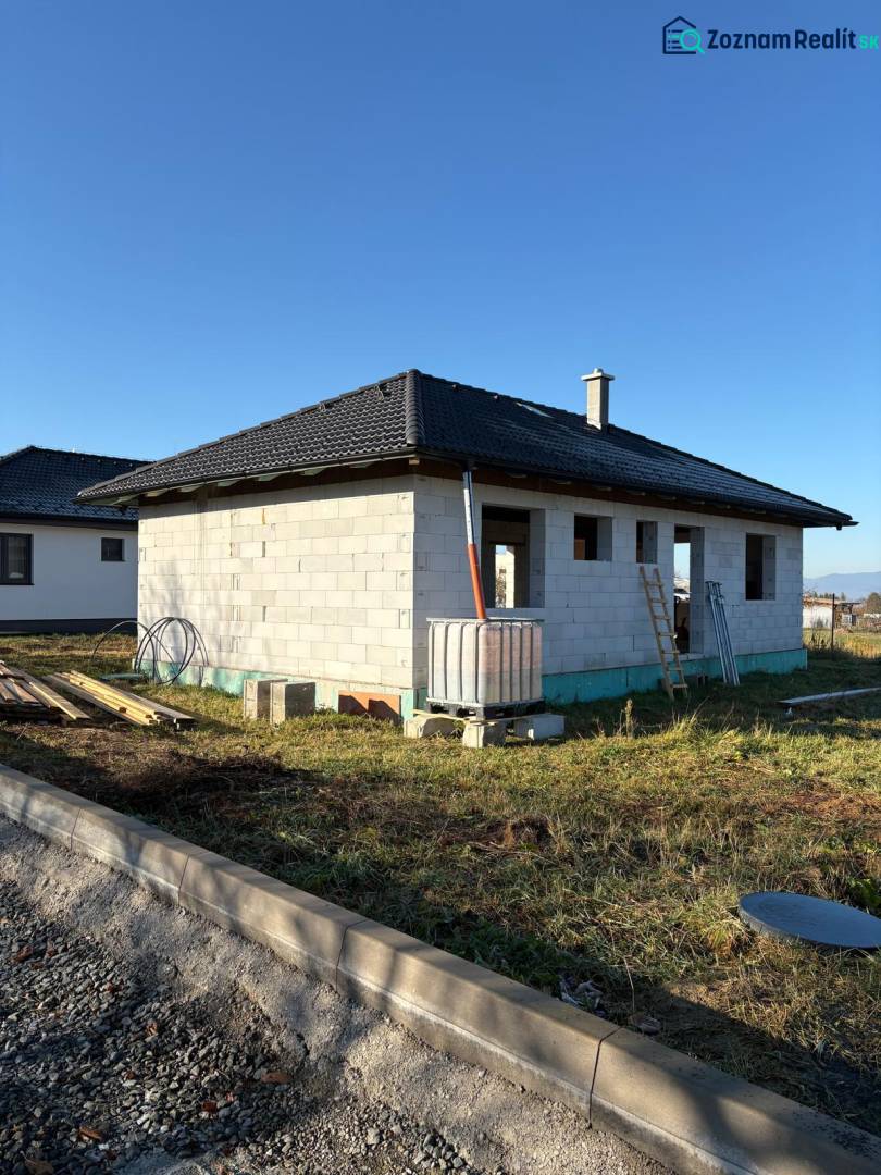 Unfinished family house in Vyšná Šebastová in Prešov with a black roof and construction material.