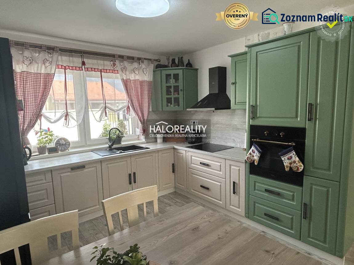 A kitchen in a family house with wooden furniture and curtains.