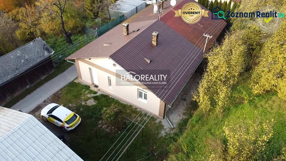A family house in Sirk with a metal roof and a car on the grassy garden.