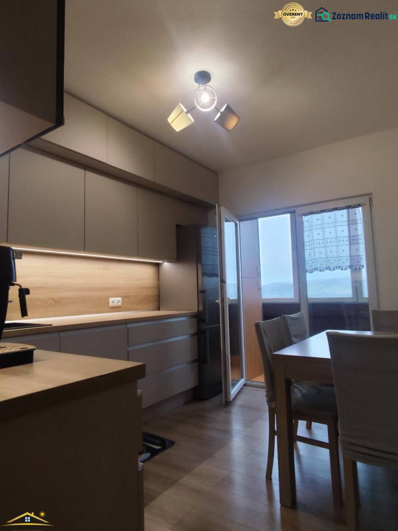 A kitchen with a wooden decor floor and a dining table in a 3-room apartment.