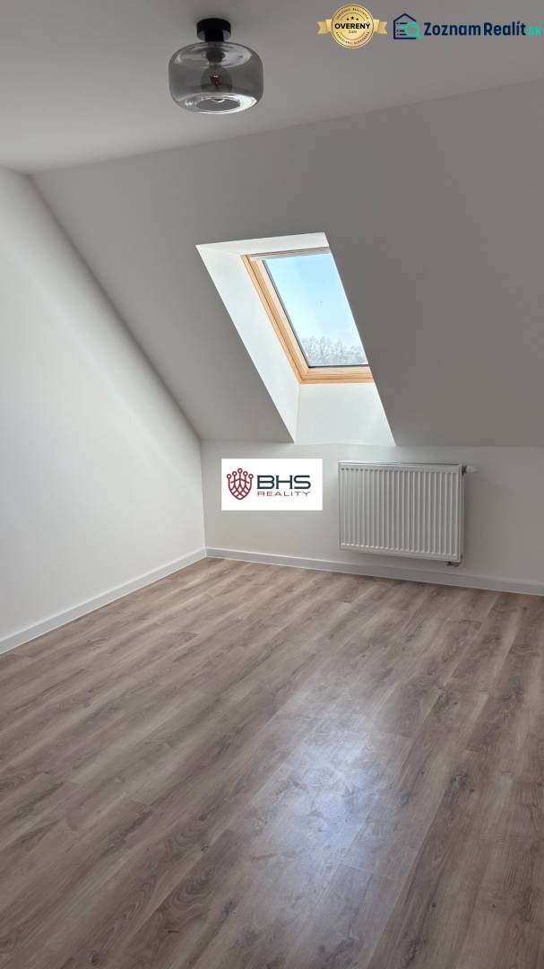 Attic room with a wooden decor floor and a skylight in a 3-room apartment.