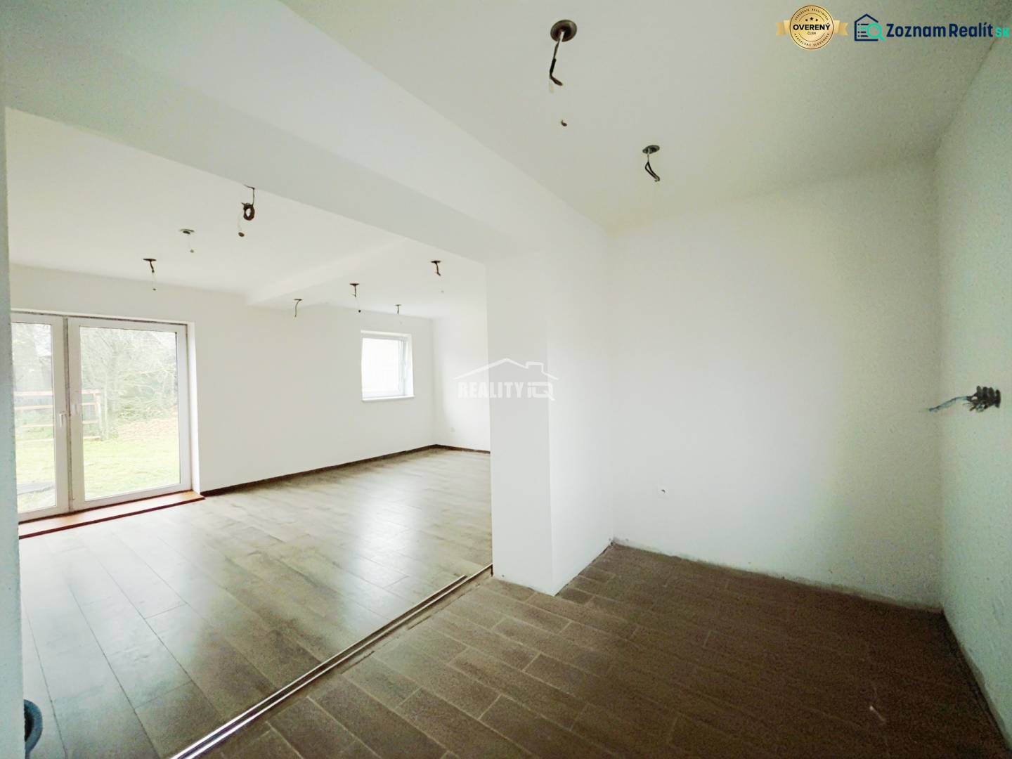 Interior of a family house with a wooden decor floor and large windows to the garden.