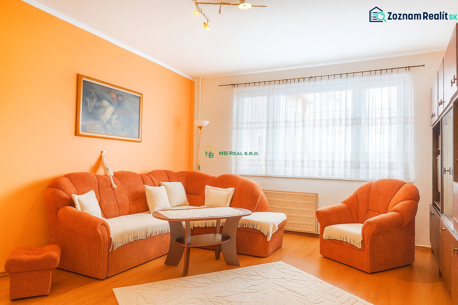 Living room with an orange sofa, wooden decor flooring, 2-room apartment.