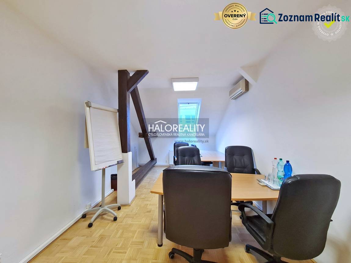 Offices with wooden decor flooring, desk, chairs, flipchart, water on the table.