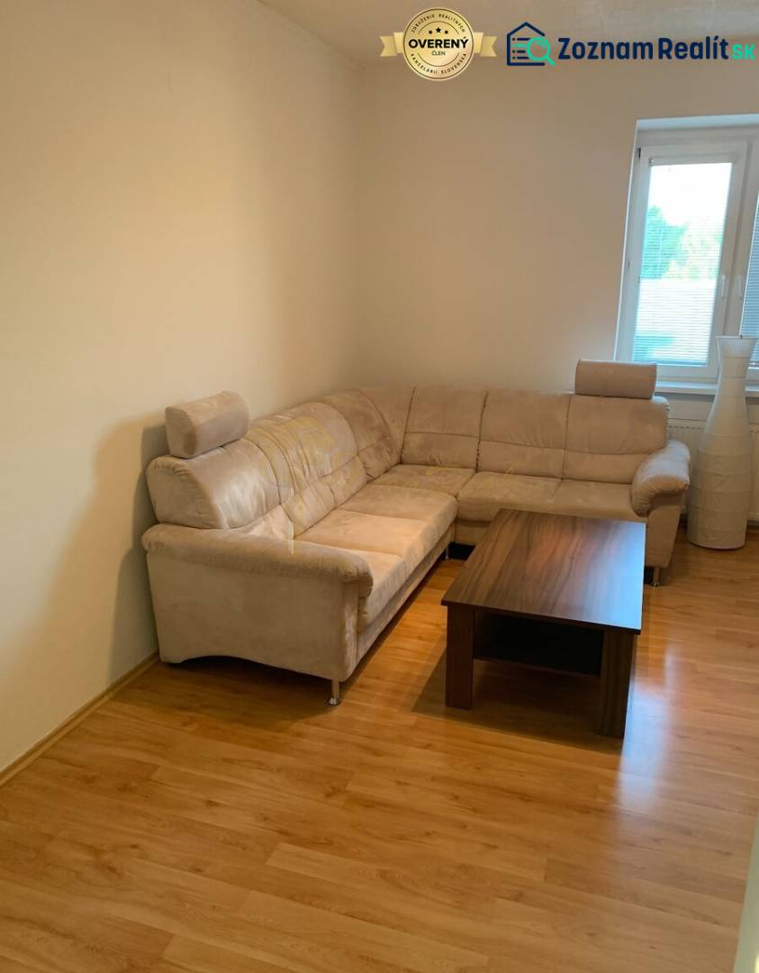 Living room with a comfortable sofa and a table on a floor with a wooden decor.