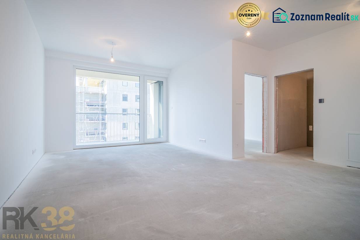 Spacious living area in a 2-room apartment with large windows without flooring with wooden decor.