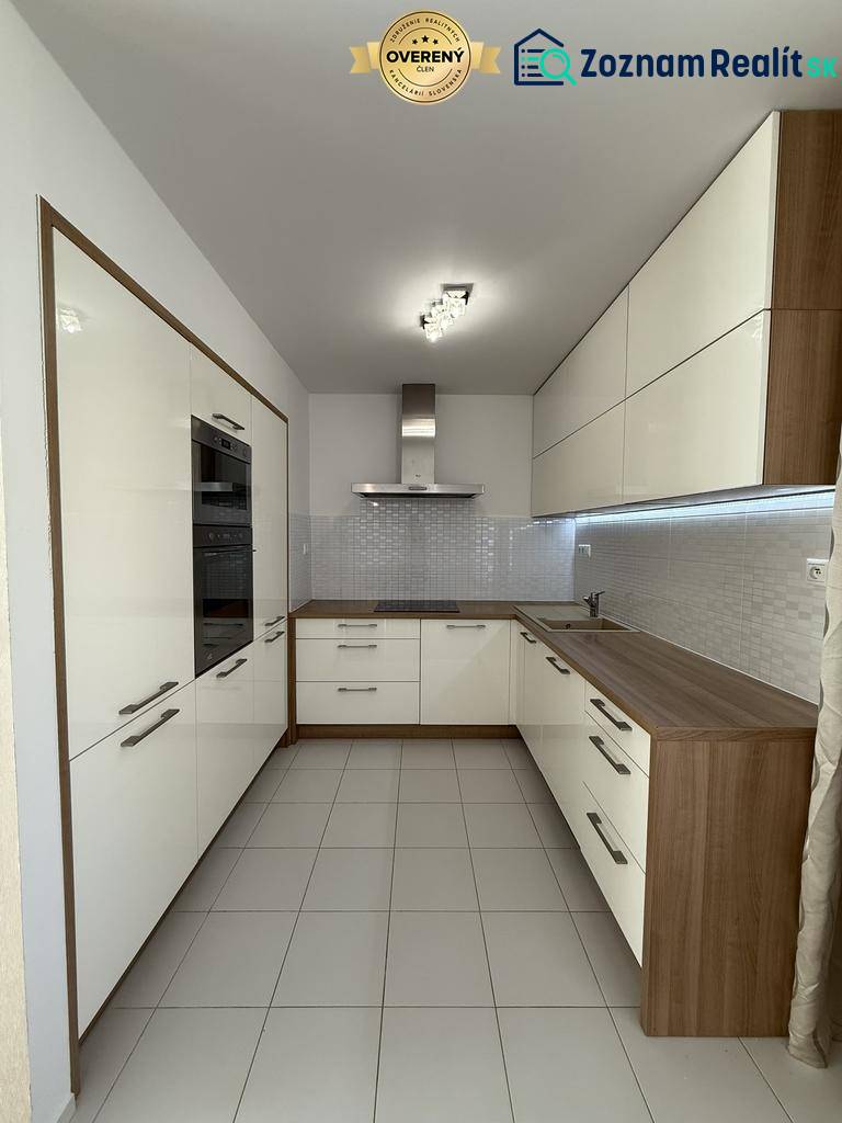 A kitchen in a 4-room apartment with light cabinets and tiled flooring.