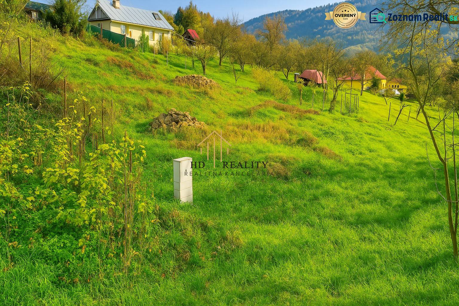 Sloping greenery in Pozemky - living in Banská Štiavnica with rural houses and trees.