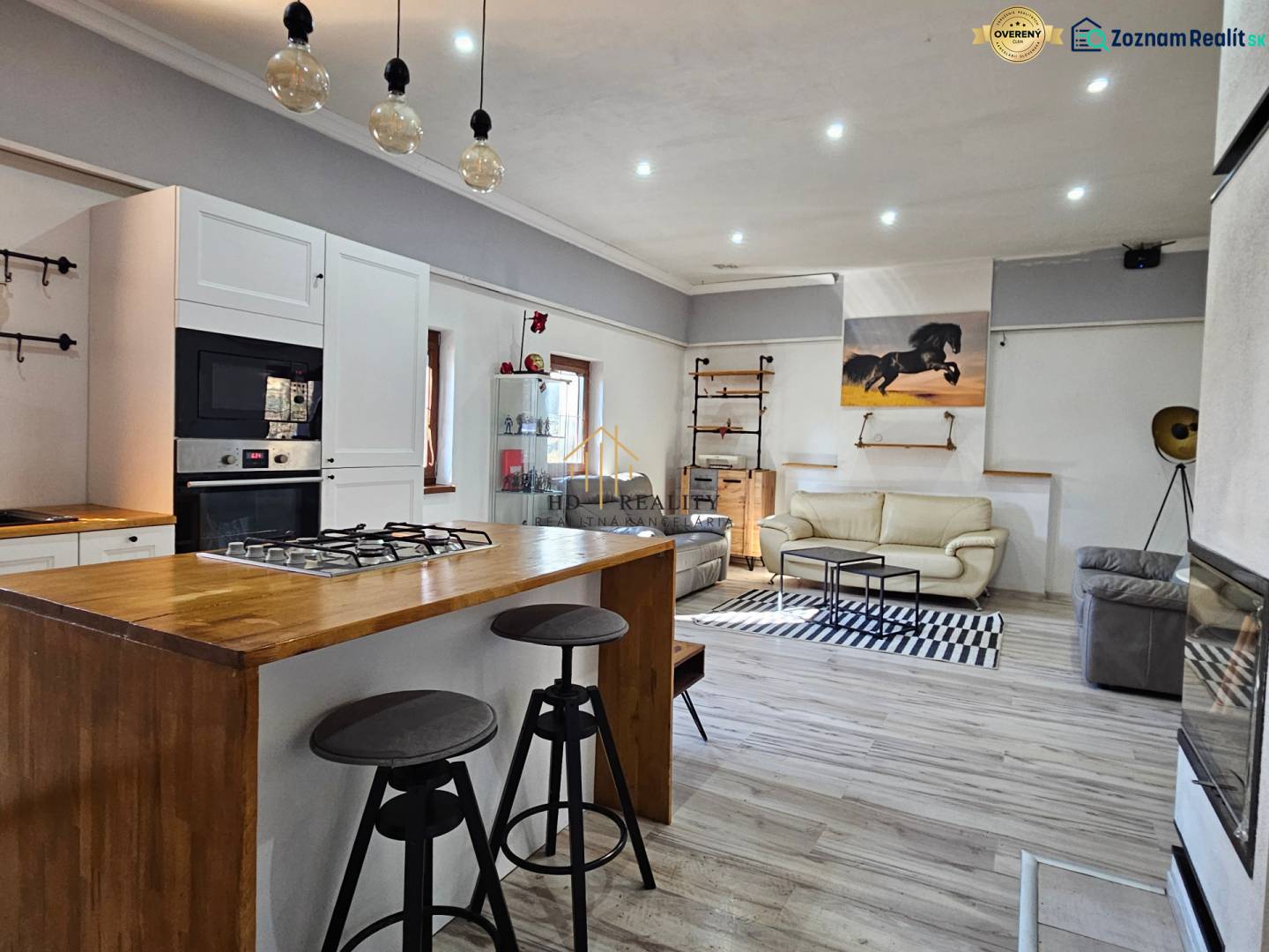 Interior of a family house with a kitchenette, wood-decorated flooring, and comfortable seating.