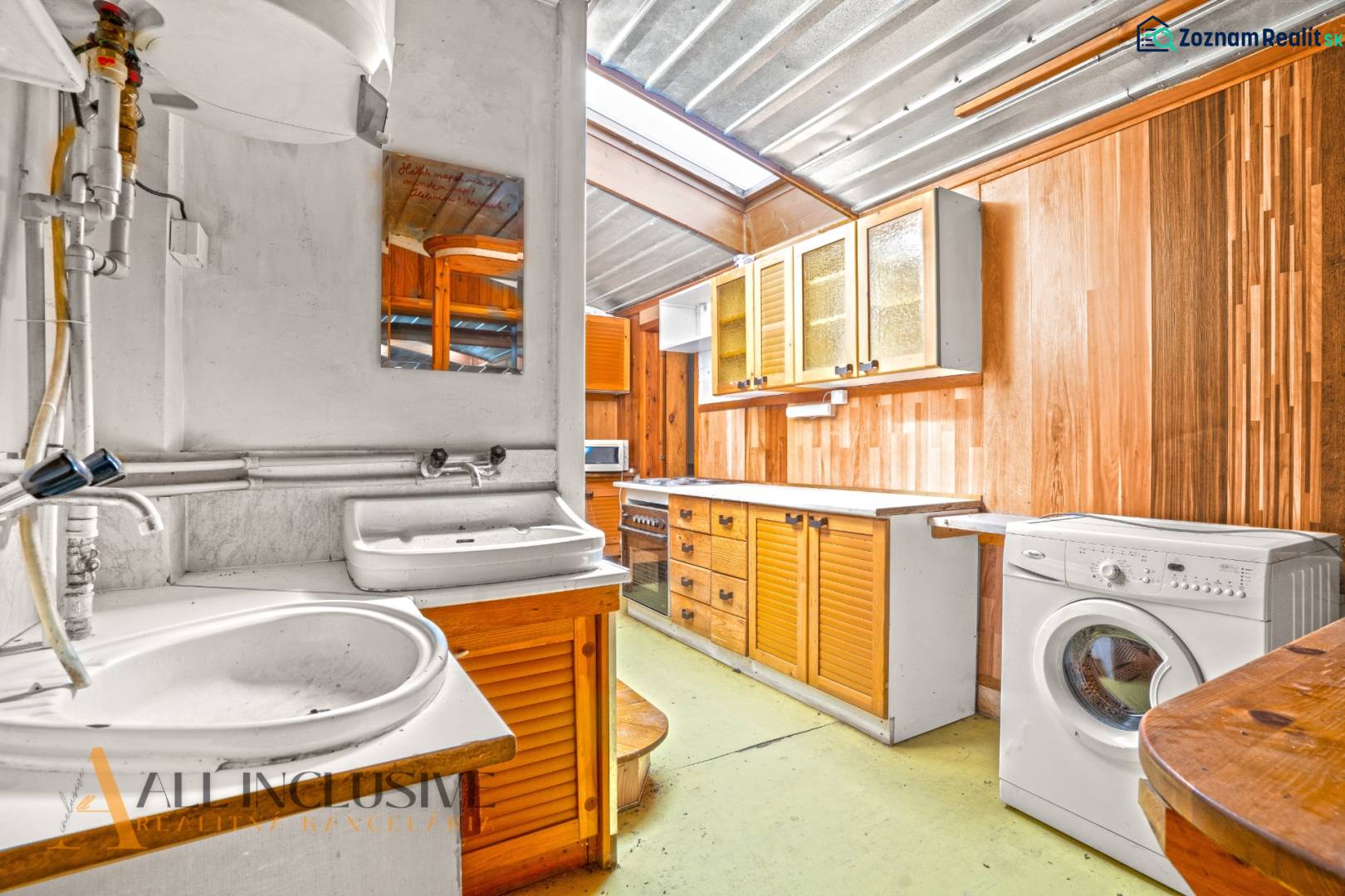 A kitchen in a family house with wooden cabinets, a sink, and a washing machine.