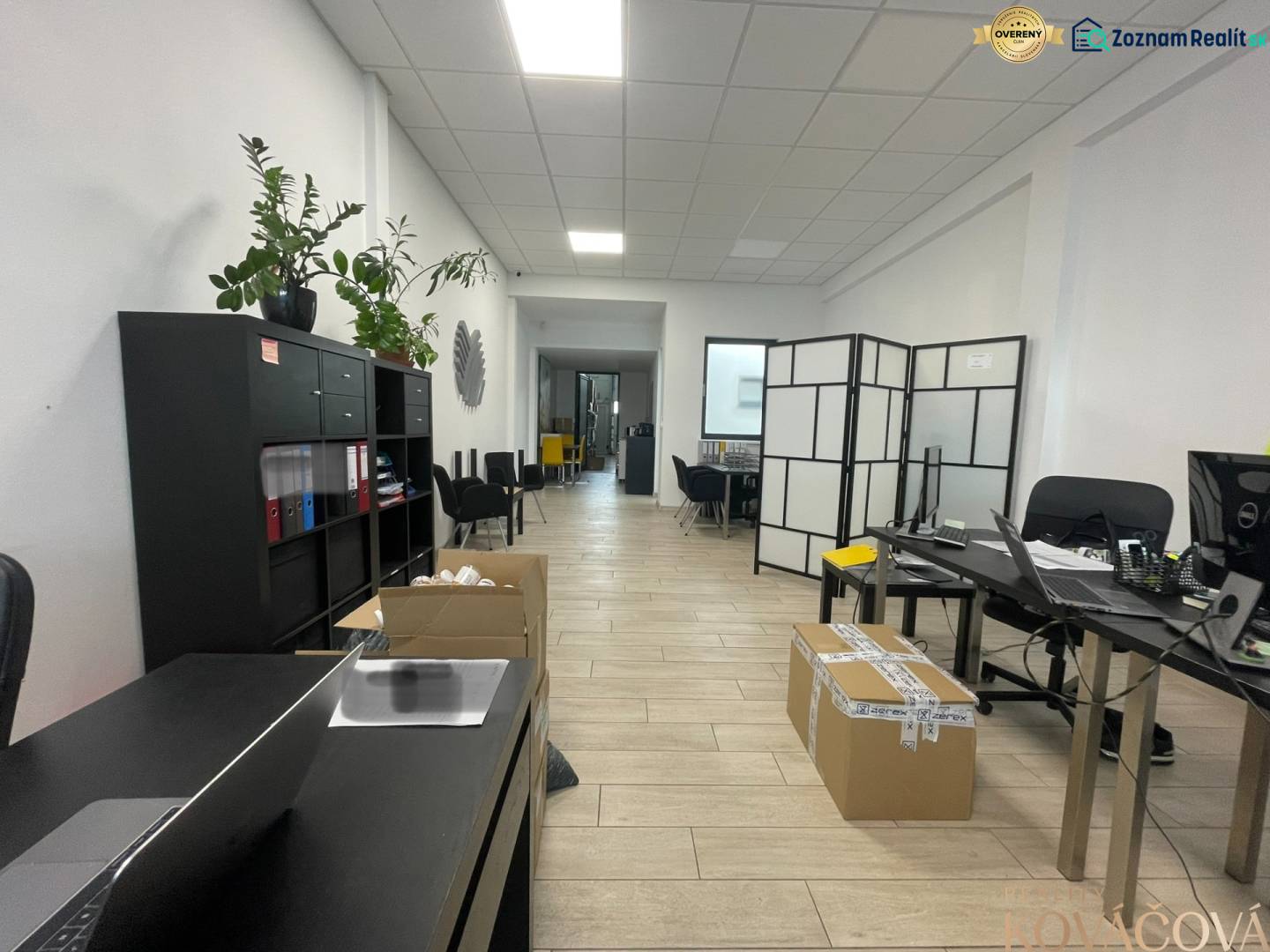 Commercial space with shelves, tables, chairs, and flooring with a wooden decor.