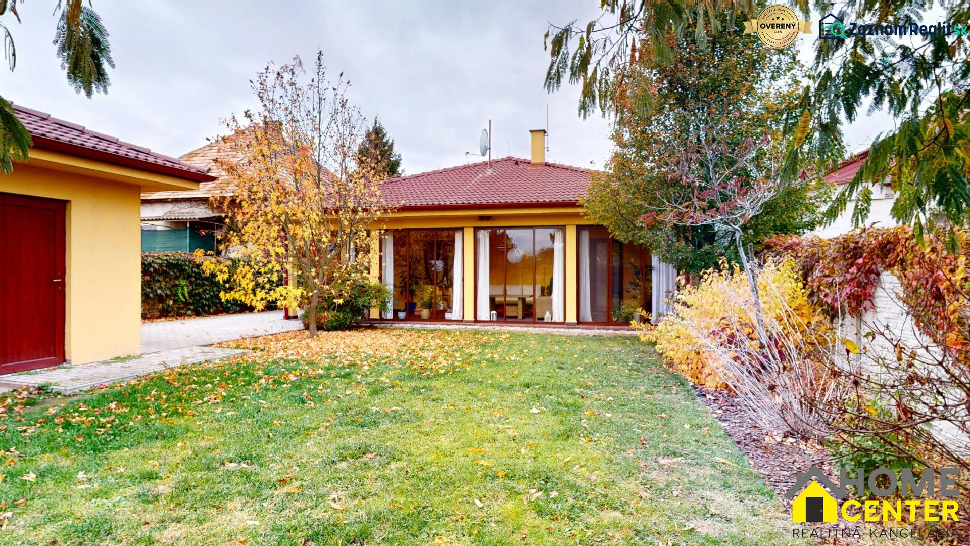 A family house on Ďatelinová Street in Iža with a garden, deciduous trees, and a lawn.