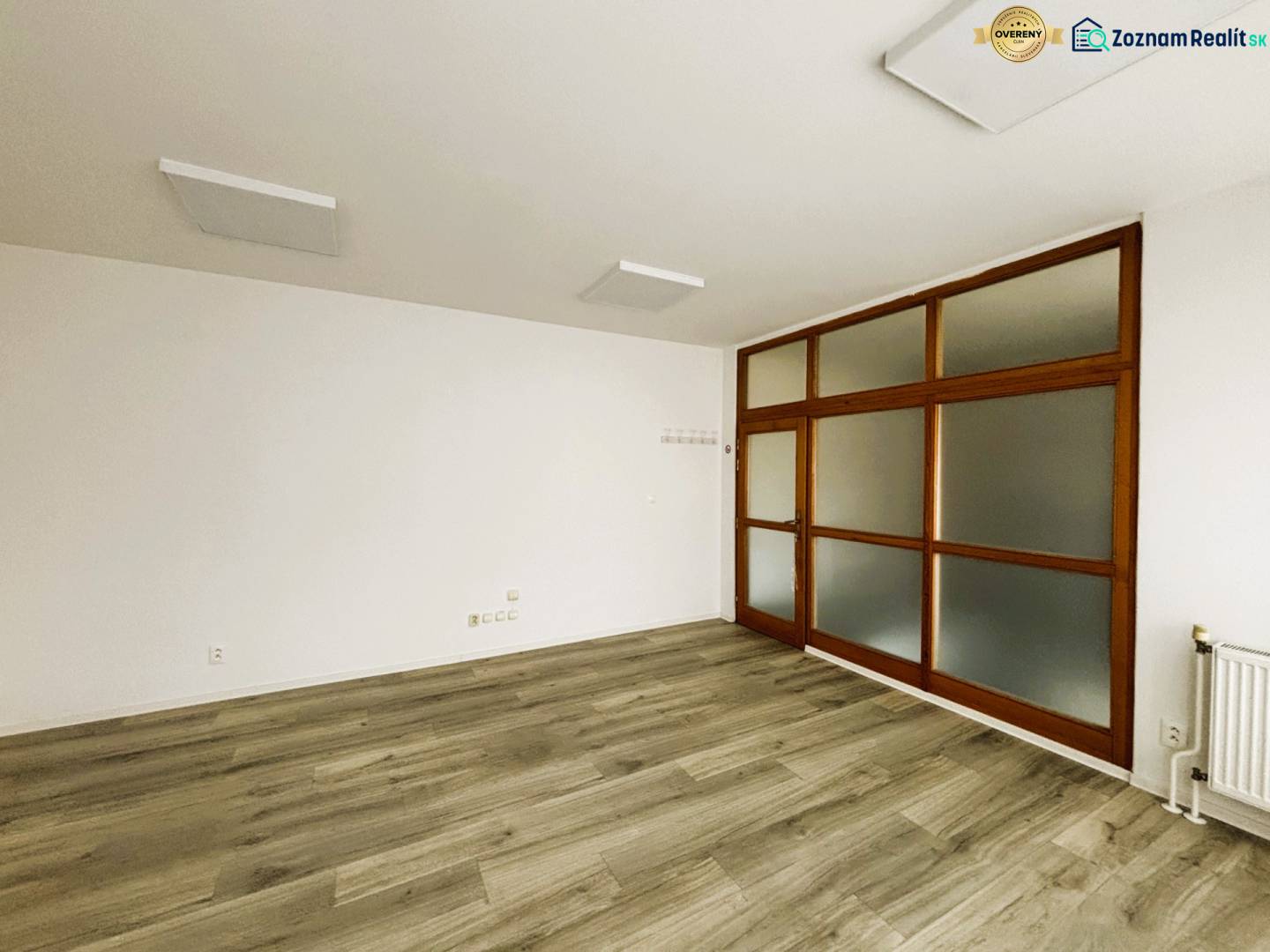 Commercial spaces with white walls and wood-patterned flooring, glass doors.