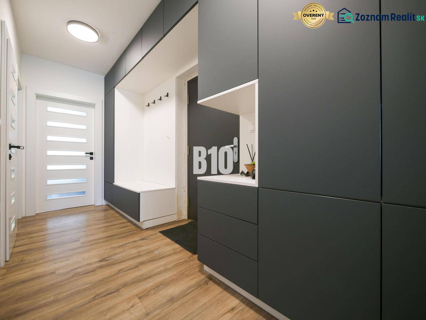 A hallway in a 3-room apartment with storage spaces and a floor with a wooden decor.