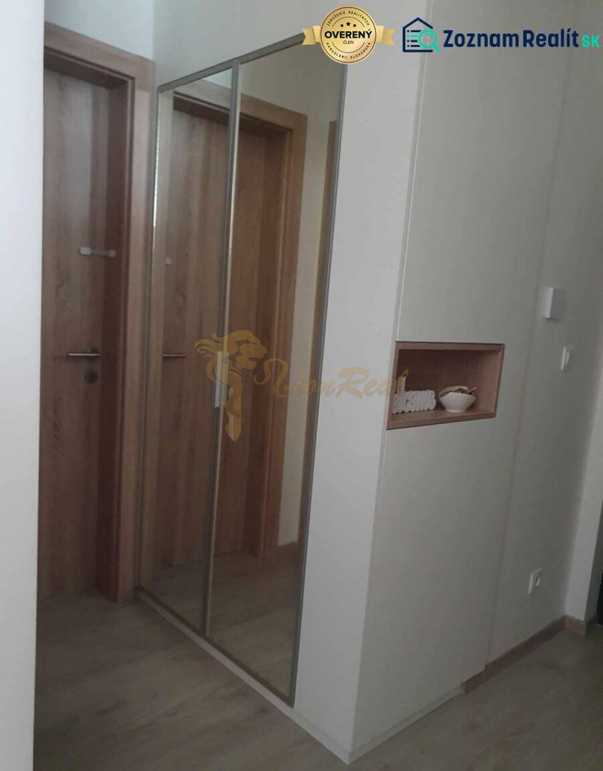 A hallway with a large mirror and a floor with a wooden decor in a 2-room apartment.