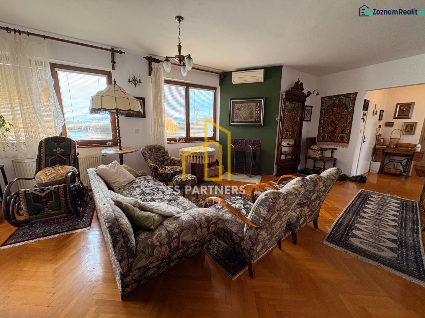 Living room in a 5 or more room apartment with a wooden decor floor and classic furniture.