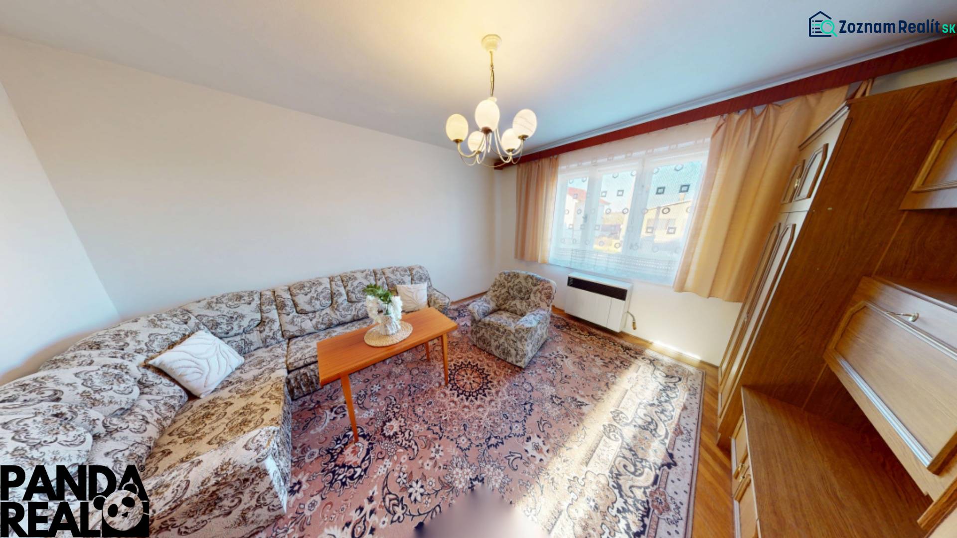 Living room in a family house with a sofa, carpet, and wooden cabinets.