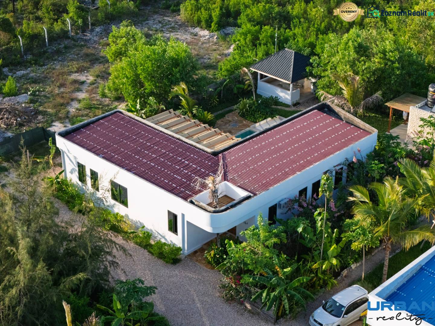 Construction of houses in Paje, Unguja South Region, with red roofs surrounded by greenery.