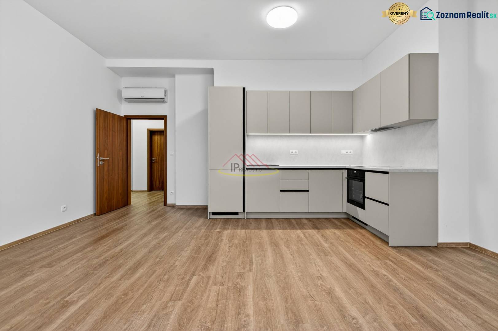 A kitchen in a 4-room apartment with a wooden decor floor and a gray kitchen unit.