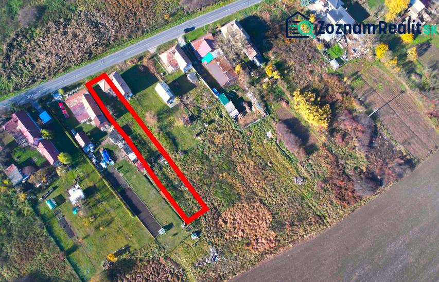 Aerial perspective of residential plots in the village of Radnovce with the main road.