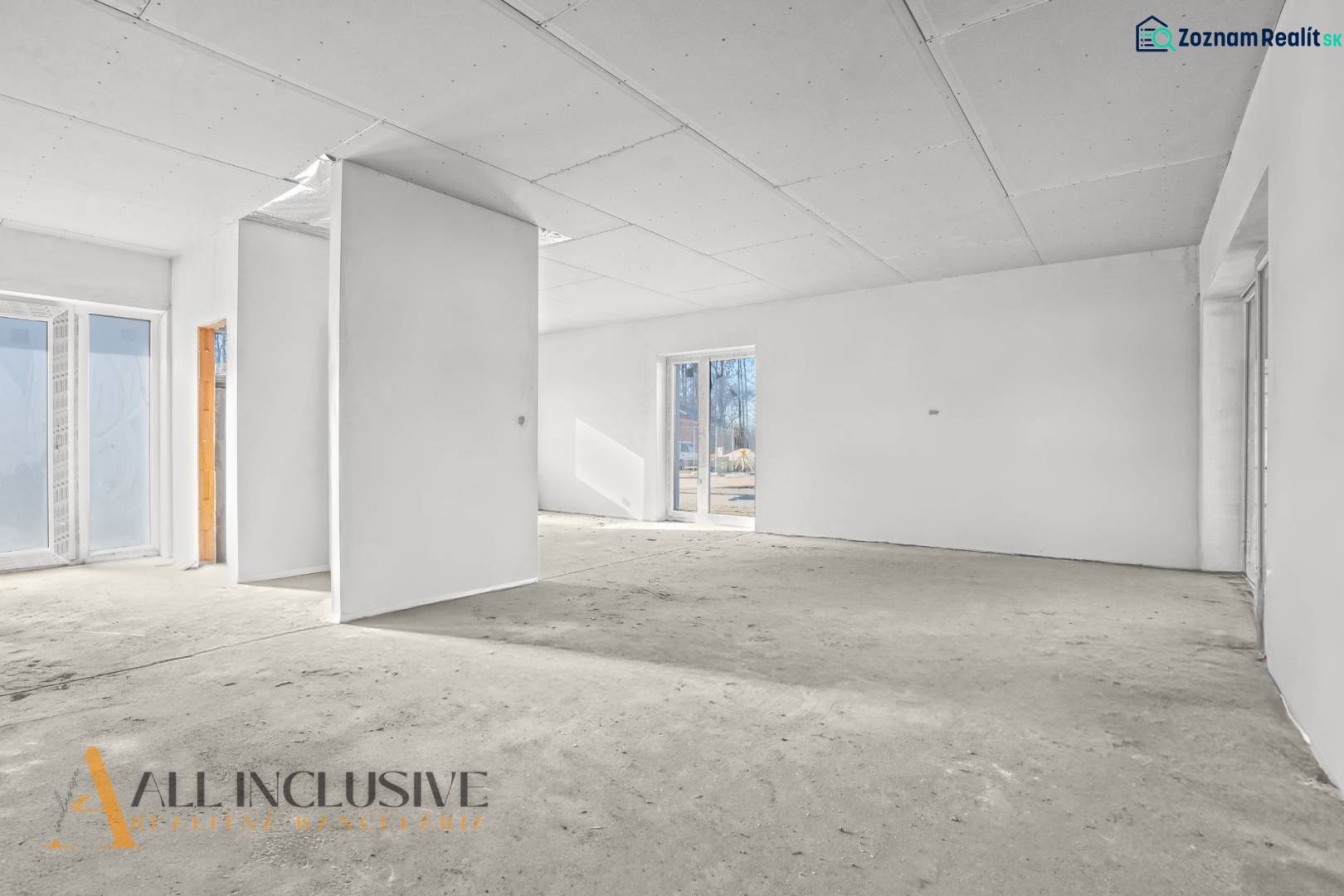 An empty interior in a family house with white walls and large windows.
