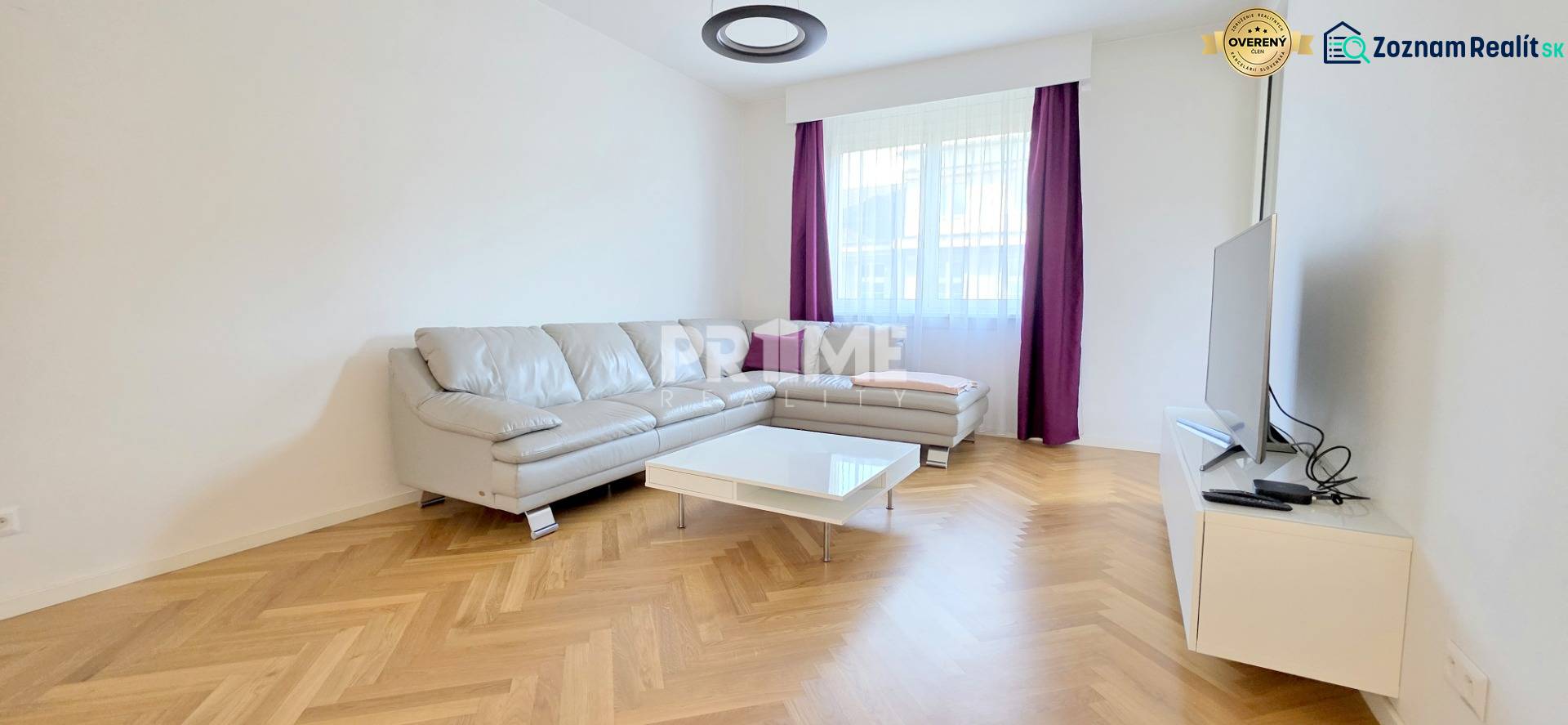 Living room with a corner sofa, purple curtains, and a wooden decor floor in a two-room apartment.