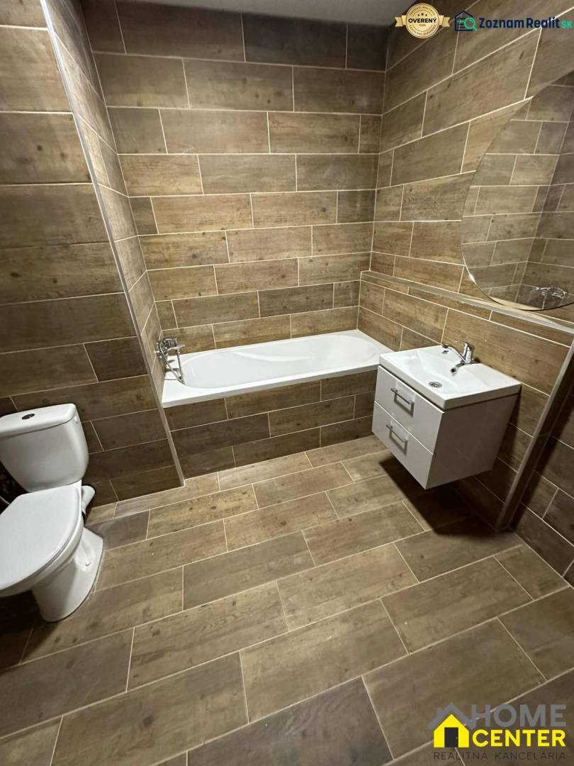 Studio apartment: Bathroom with a bathtub, toilet, and sink, floor with wood decor.