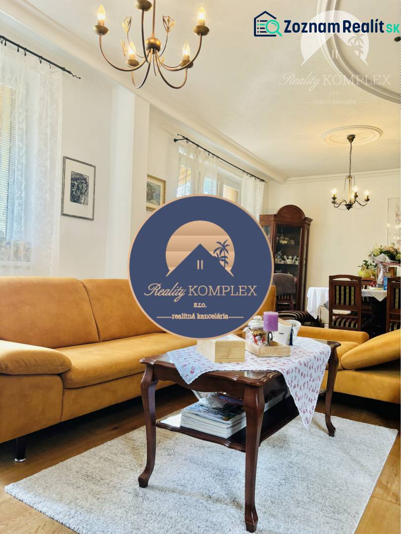 Living room in a family house with yellow sofas and a chandelier, floor with wood decor.