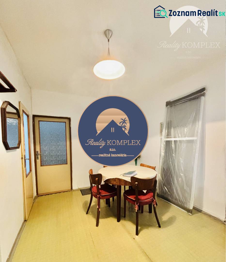 Dining room in a 2-room apartment with a simple wooden table and chairs.