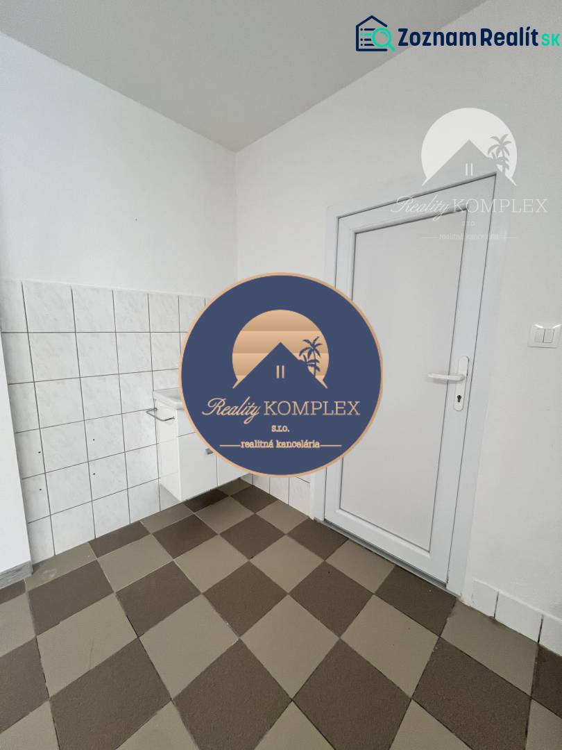 Commercial space with a checkered floor and white walls, featuring a door and a sink.