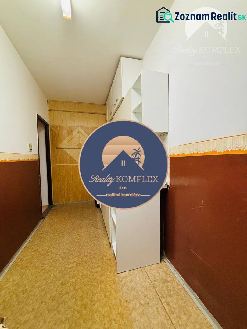 Hallway in a 3-room apartment, light walls, wooden paneling, built-in cabinets.