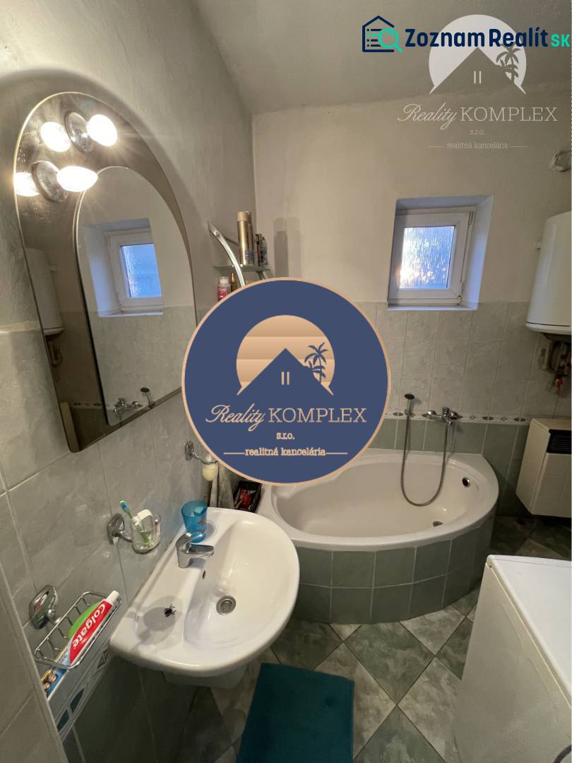 Bathroom in a family house with a bathtub, sink, and window.
