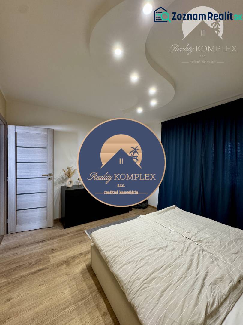 A bedroom in a 4-room apartment with light wooden furniture and curtains.