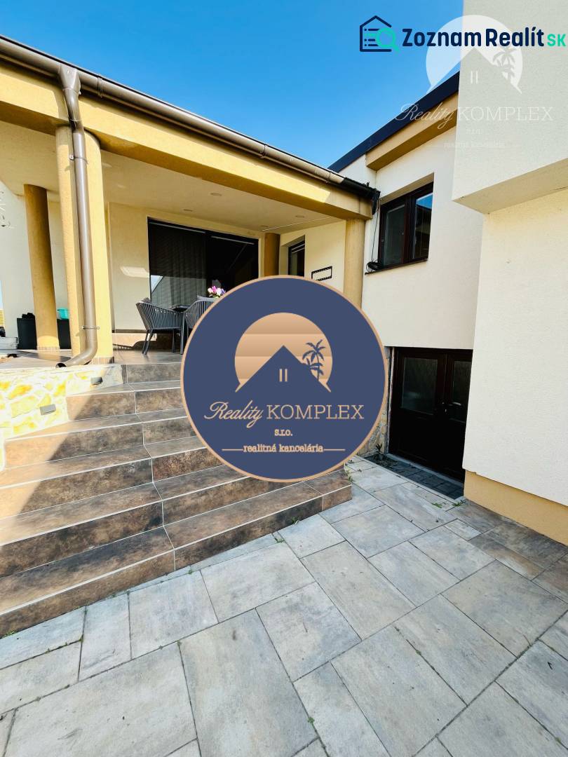 Family house with a terrace, garden furniture, and a paved staircase, ideal for outdoor relaxation.