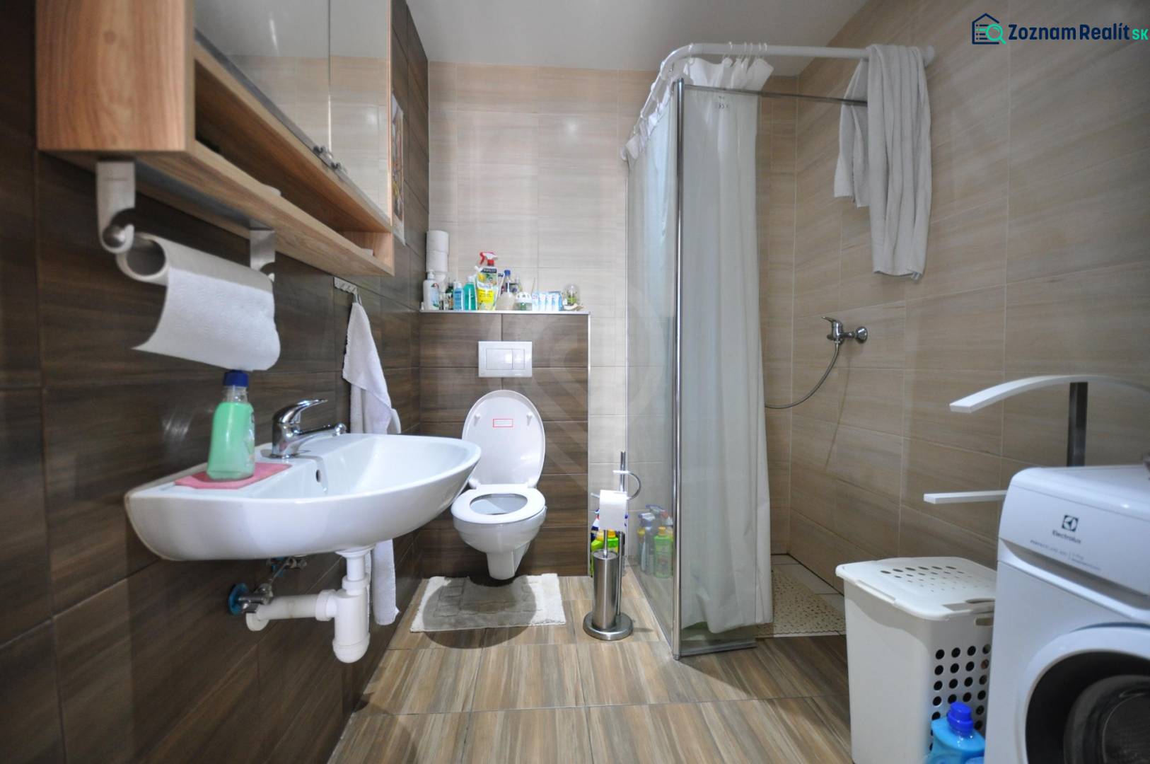 A bathroom in a 2-room apartment with wooden decor, a sink, a toilet, and a shower.
