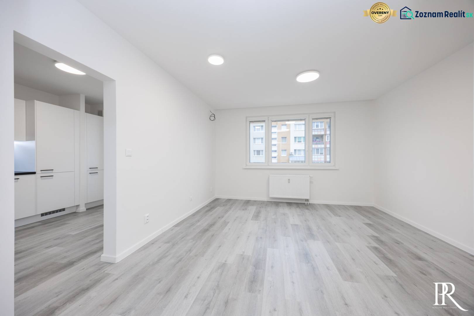 A spacious room in a 3-room apartment with a wooden decor floor and large windows.