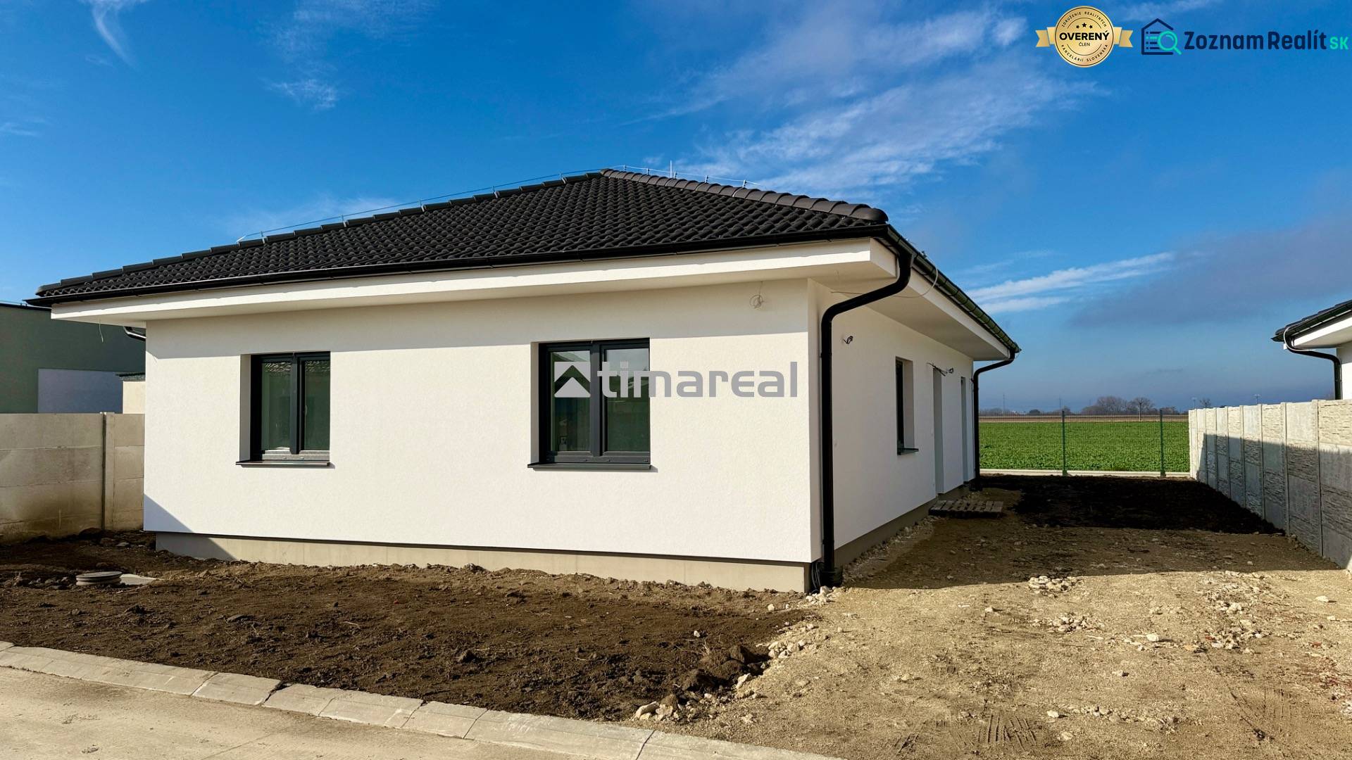 A family house with a white facade and a black roof in Topoľnica.