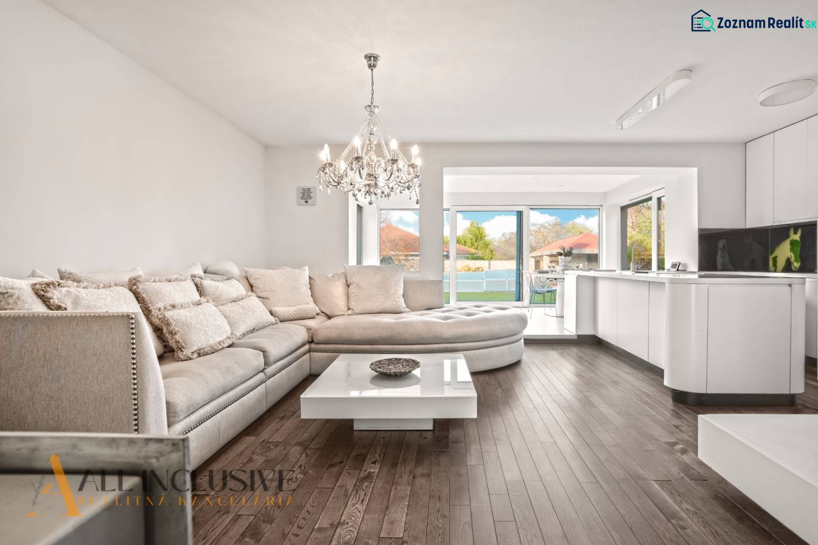 Interior of a family house with a sofa, chandelier, and wooden decor flooring.