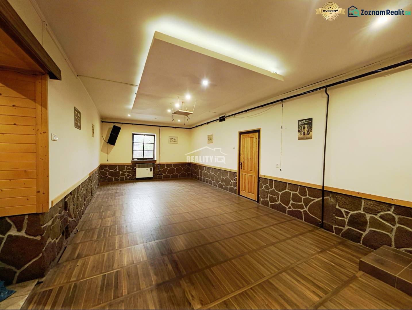 A decorated room with a wooden decor floor, stone, and wooden elements in a family house.