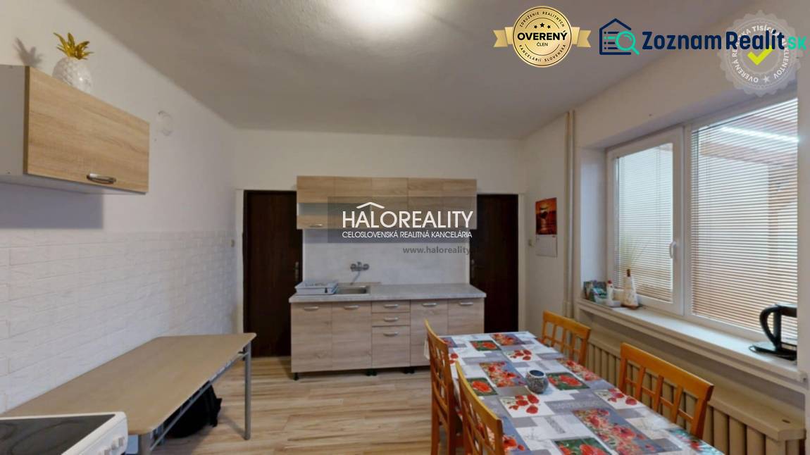 A kitchen in a family house with a dining table, cabinets, and a floor with a wooden decor.