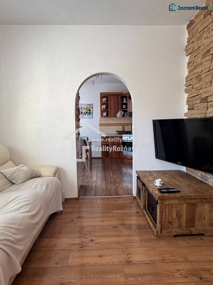 Living room in a three-room apartment with a wooden decor floor and an arched passage.