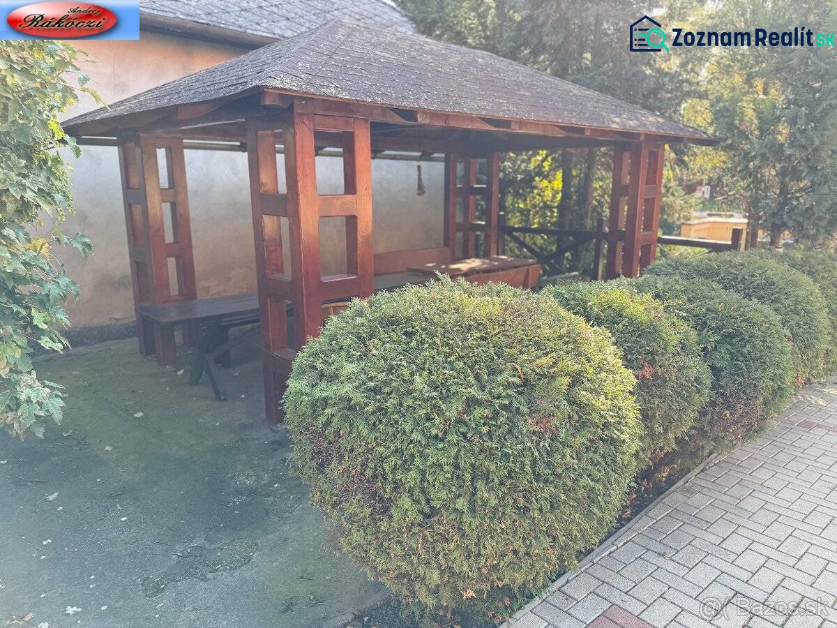 A wooden gazebo surrounded by greenery near commercial premises on Park and main road, Veľké Ludince.